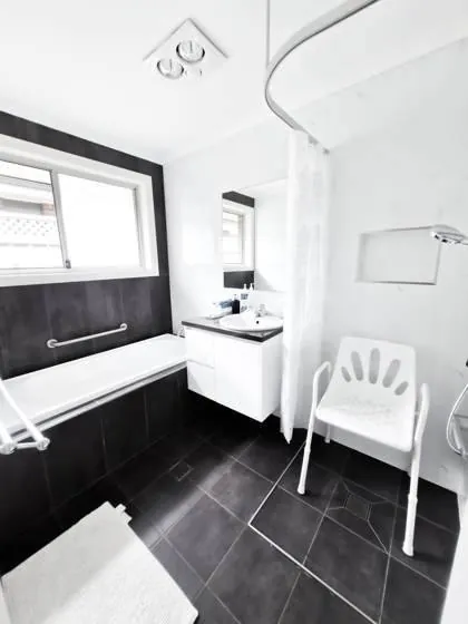 Accessible bathroom with grab rails and shower chair
