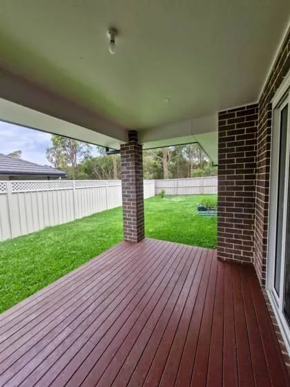 Covered back deck overlooking a grassed yard